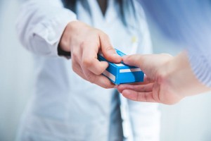 ein Apotheker übergibt einem Patienten ein Medikament
